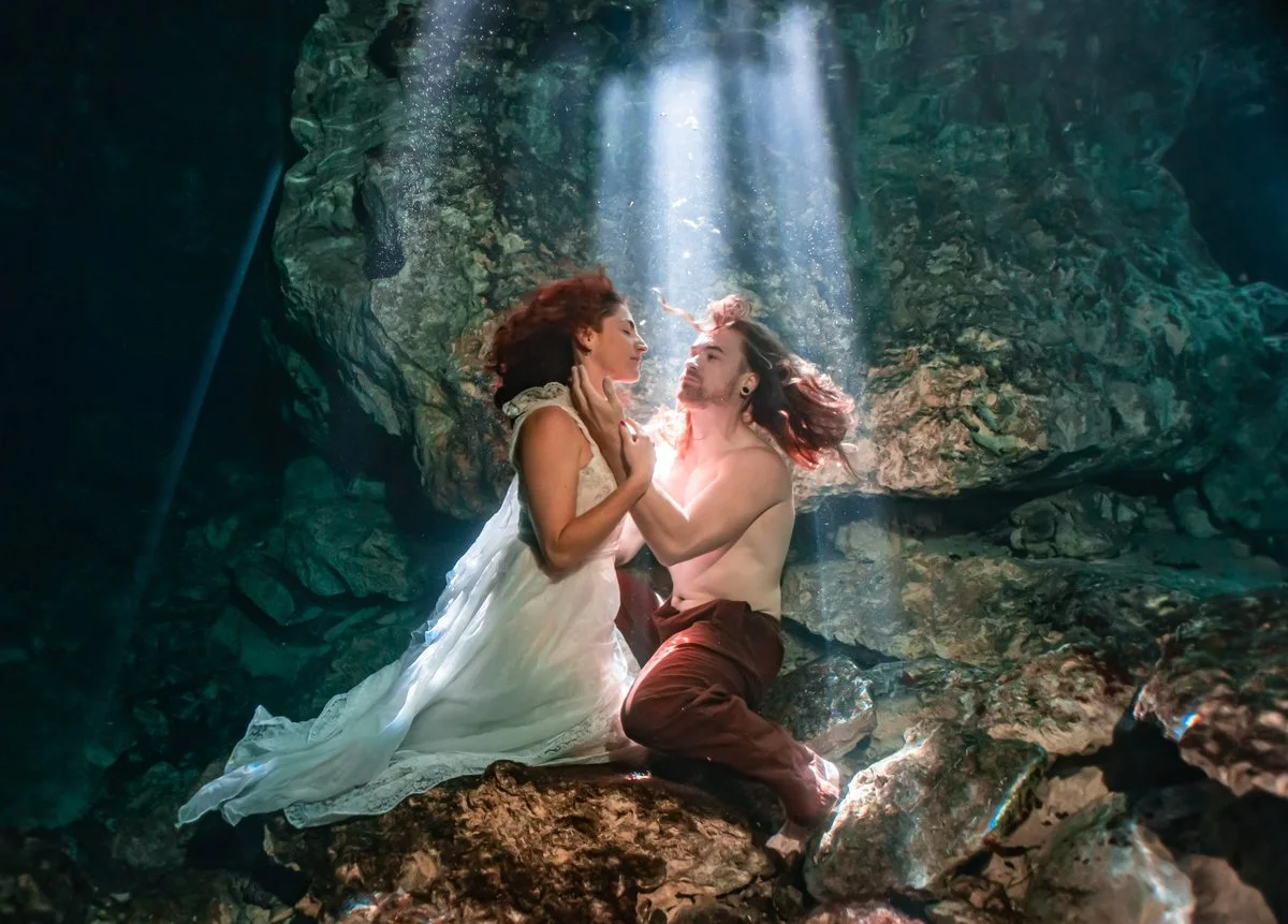 A couple meeting beneath the surface of a cenote