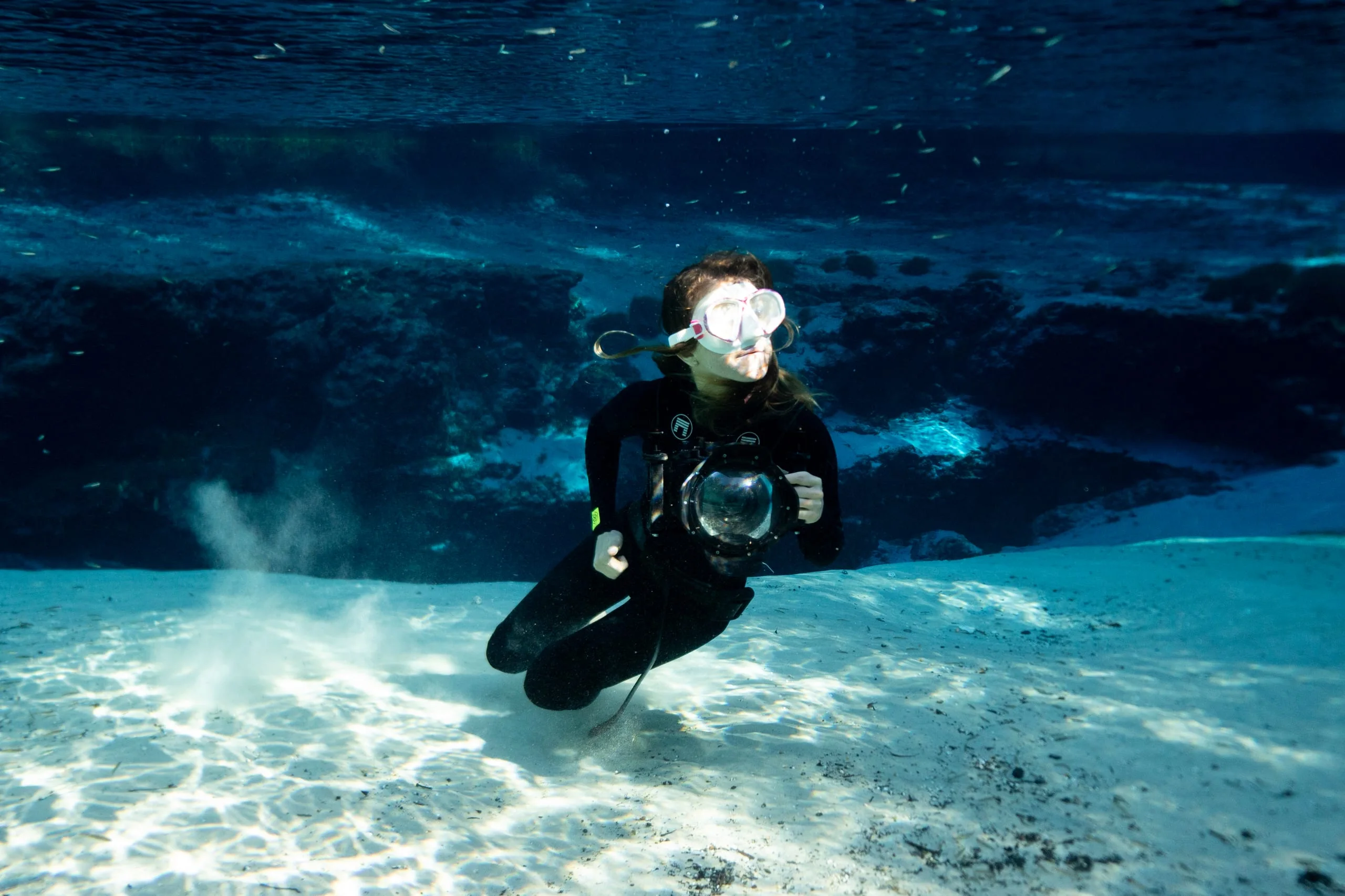 Marina on the cenote floor with her underwater camera